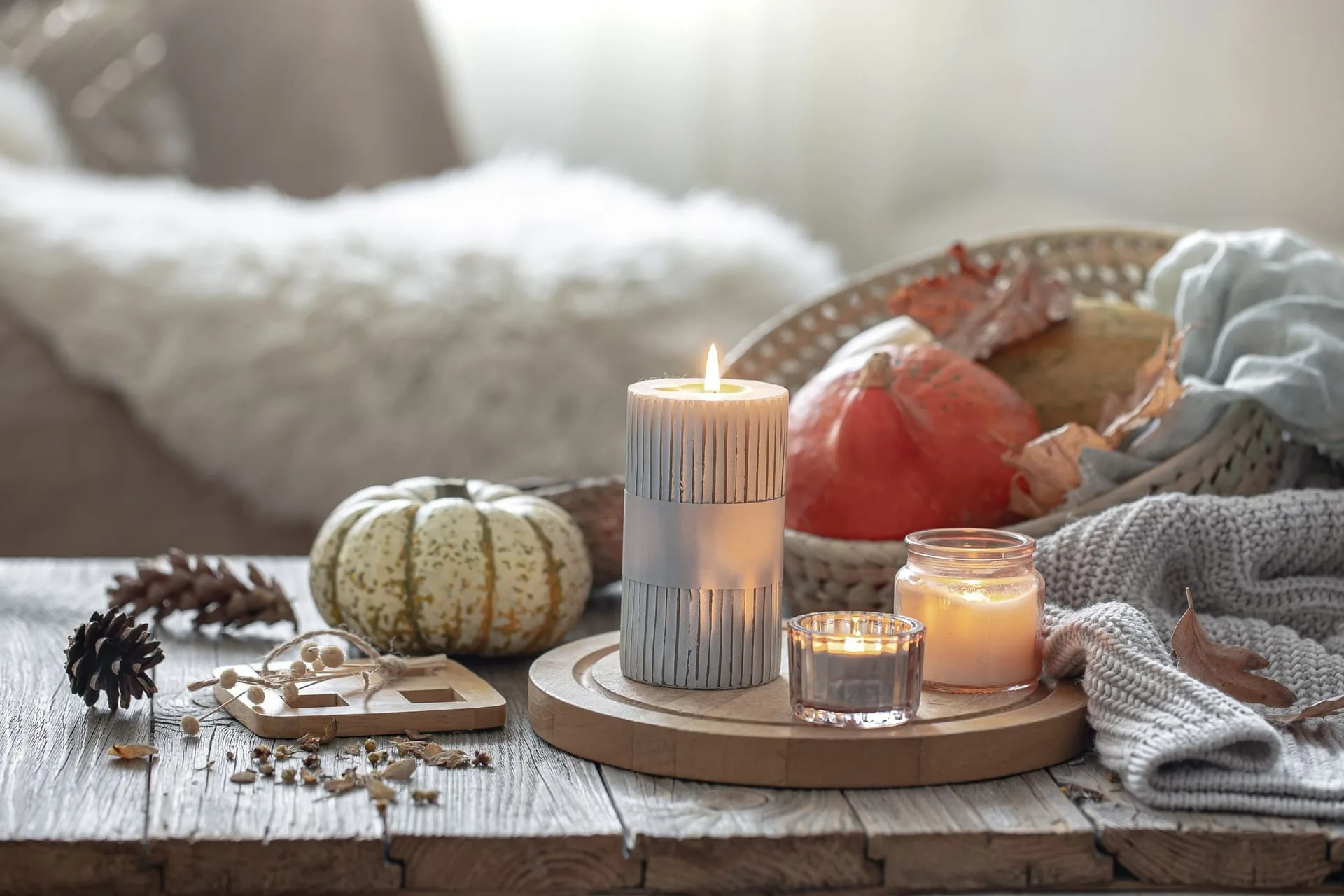 Small amber bottles of essential oils beside a ceramic burner and wooden tray